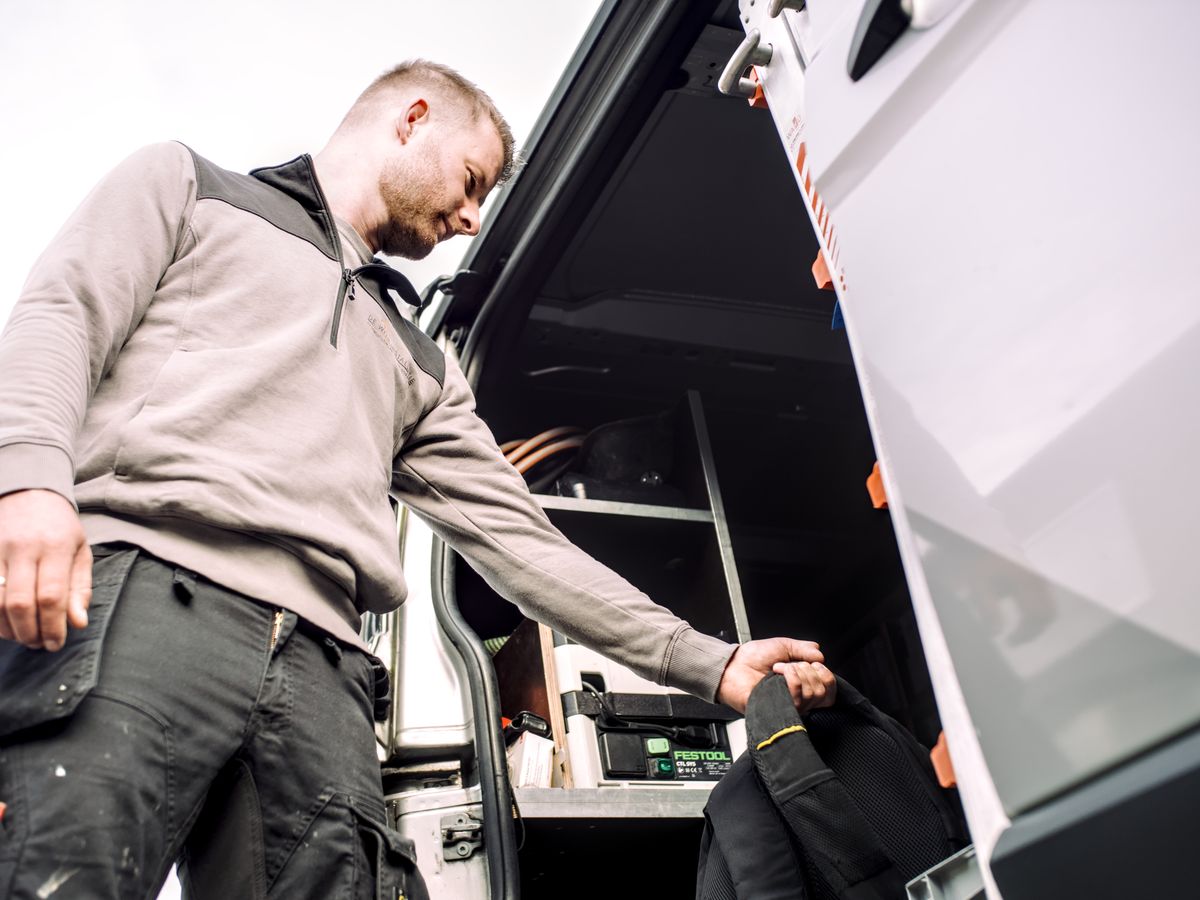 Jasper pakt gereedschap uit de bedrijfsbus